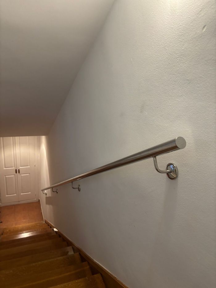 Pasamanos de acero inoxidable en escalera de madera
