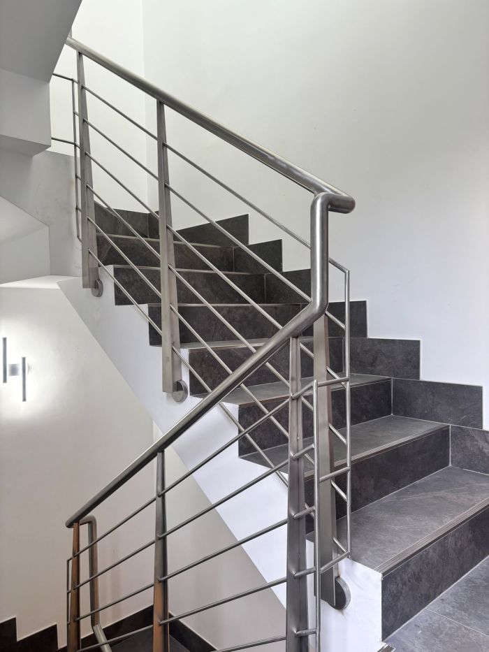 Barandilla de acero inoxidable con varillas en escalera de vivienda