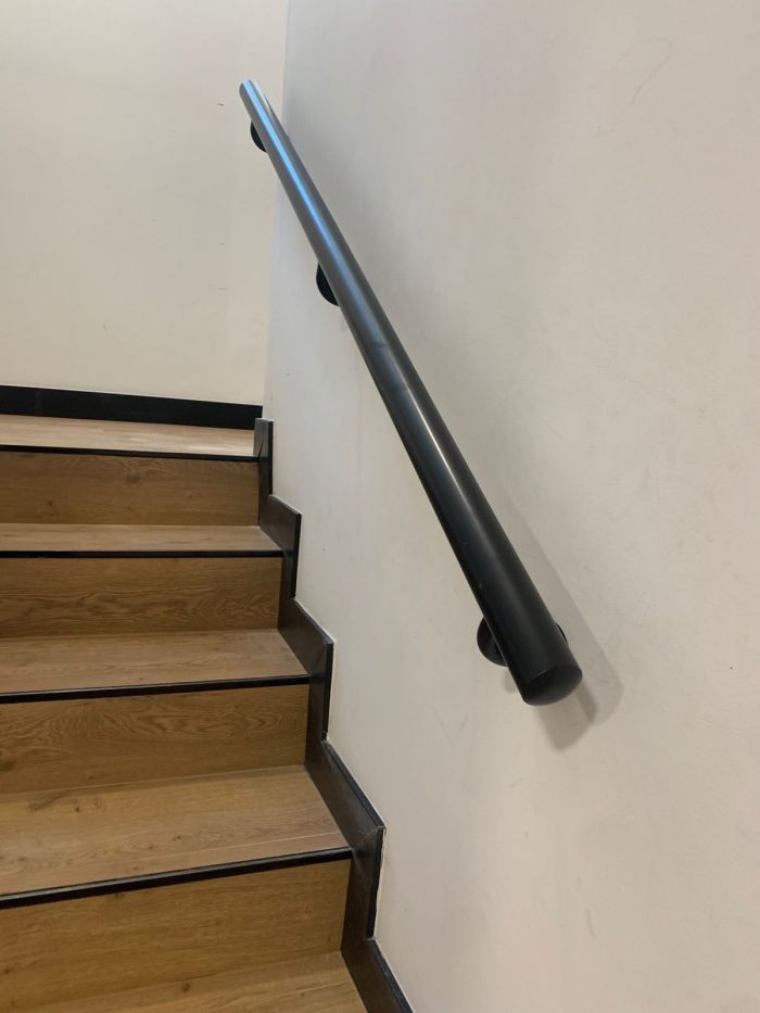 Pasamanos negro a pared en escalera de madera