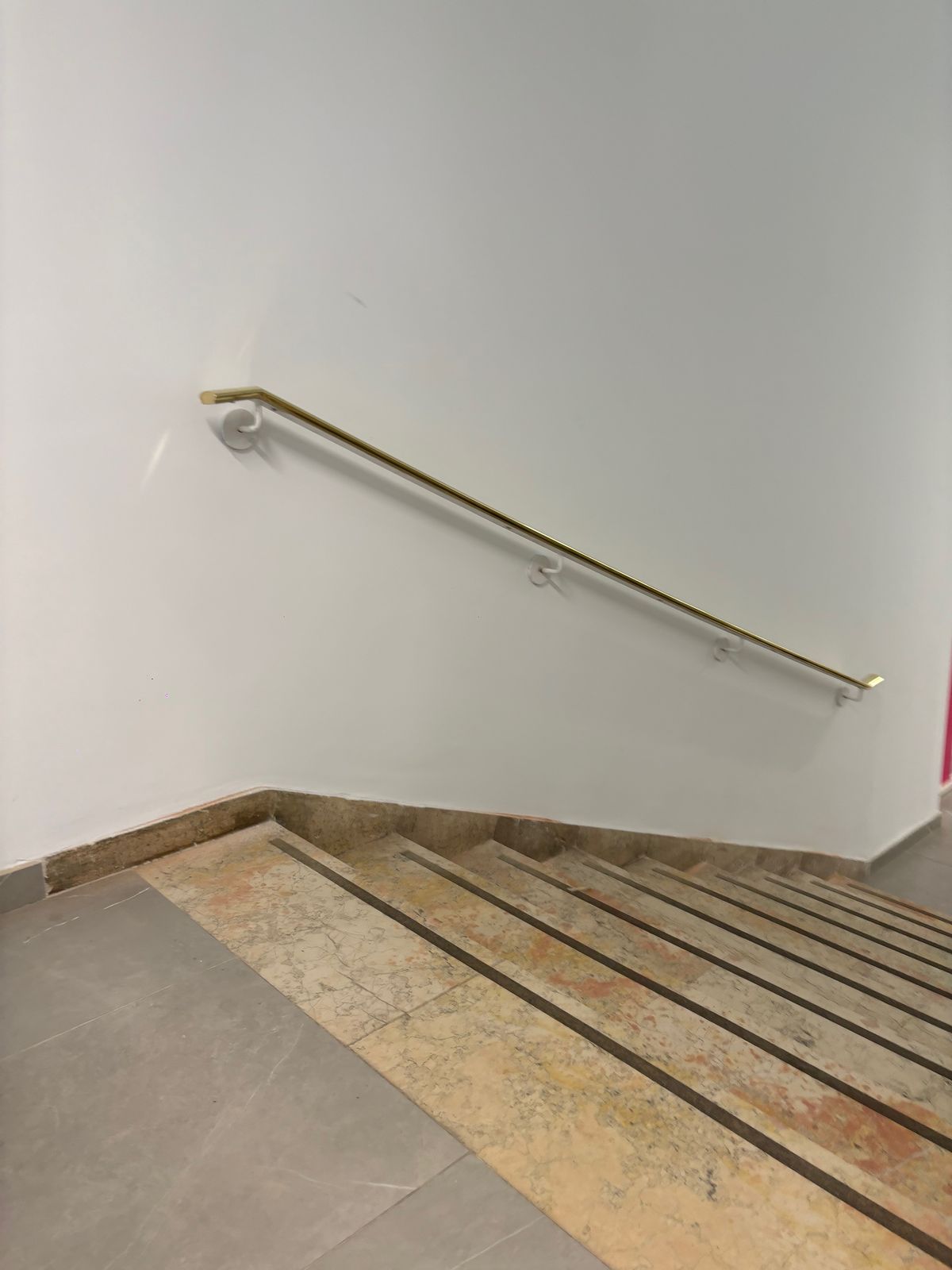 Pasamanos de latón a pared en escalera de comunidad